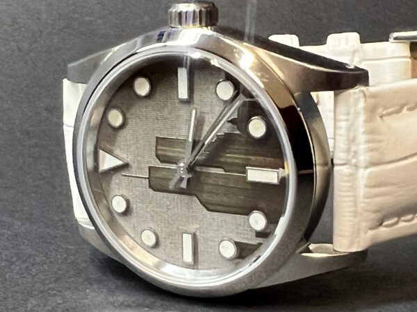 A close up of the Ladies' watch face on a grey background